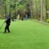 Professional artificial grass installers finishing a backyard lawn installation in the Seattle, Washington area