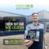 Synthetic Turf Northwest - New Fife, WA location open. Man holding a postcard that has the image of synthetic turf nw warehouse on it. INclude now open and the address. Phone number is 4257880718