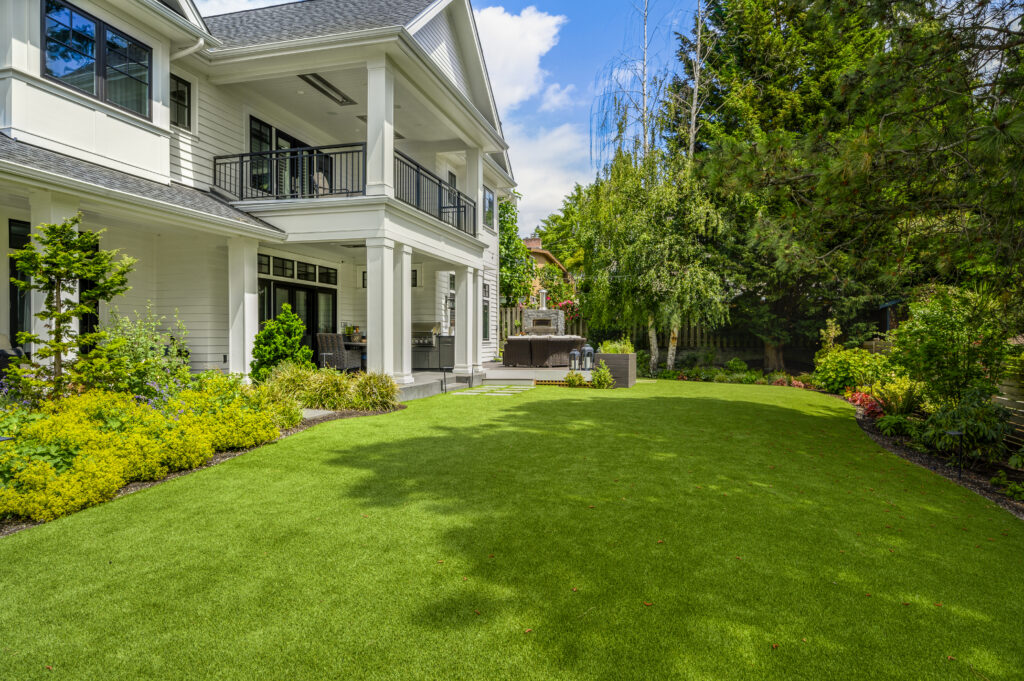 Large white house on the left with artificial turf installed by synthetic turf northwest.