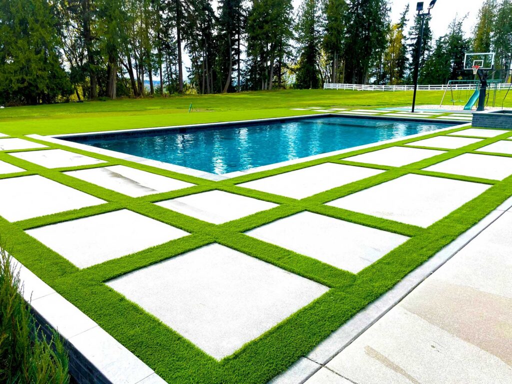 Modern pool with green landscaping.